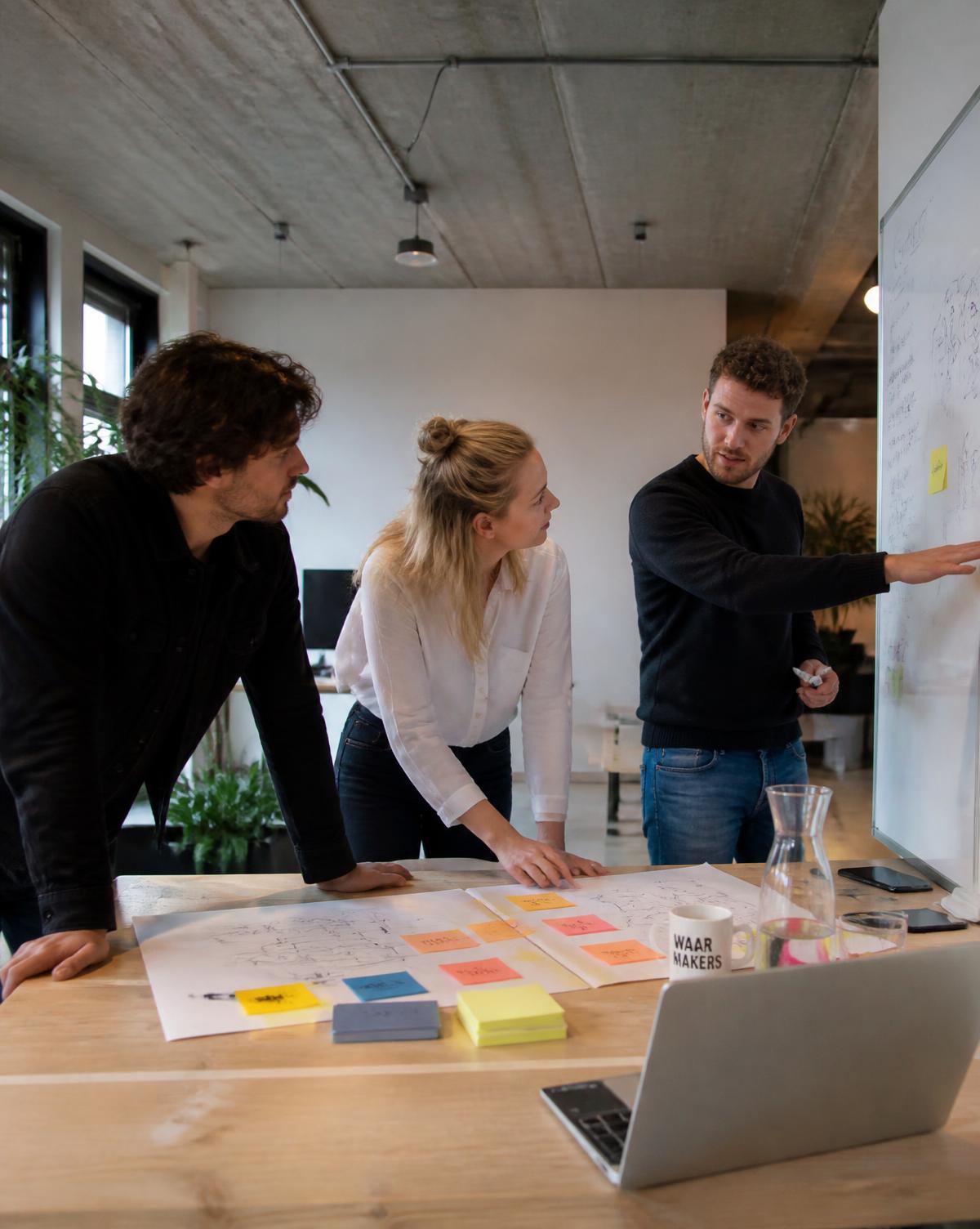 Collega's onderzoeken samen een vraagstuk aan tafel